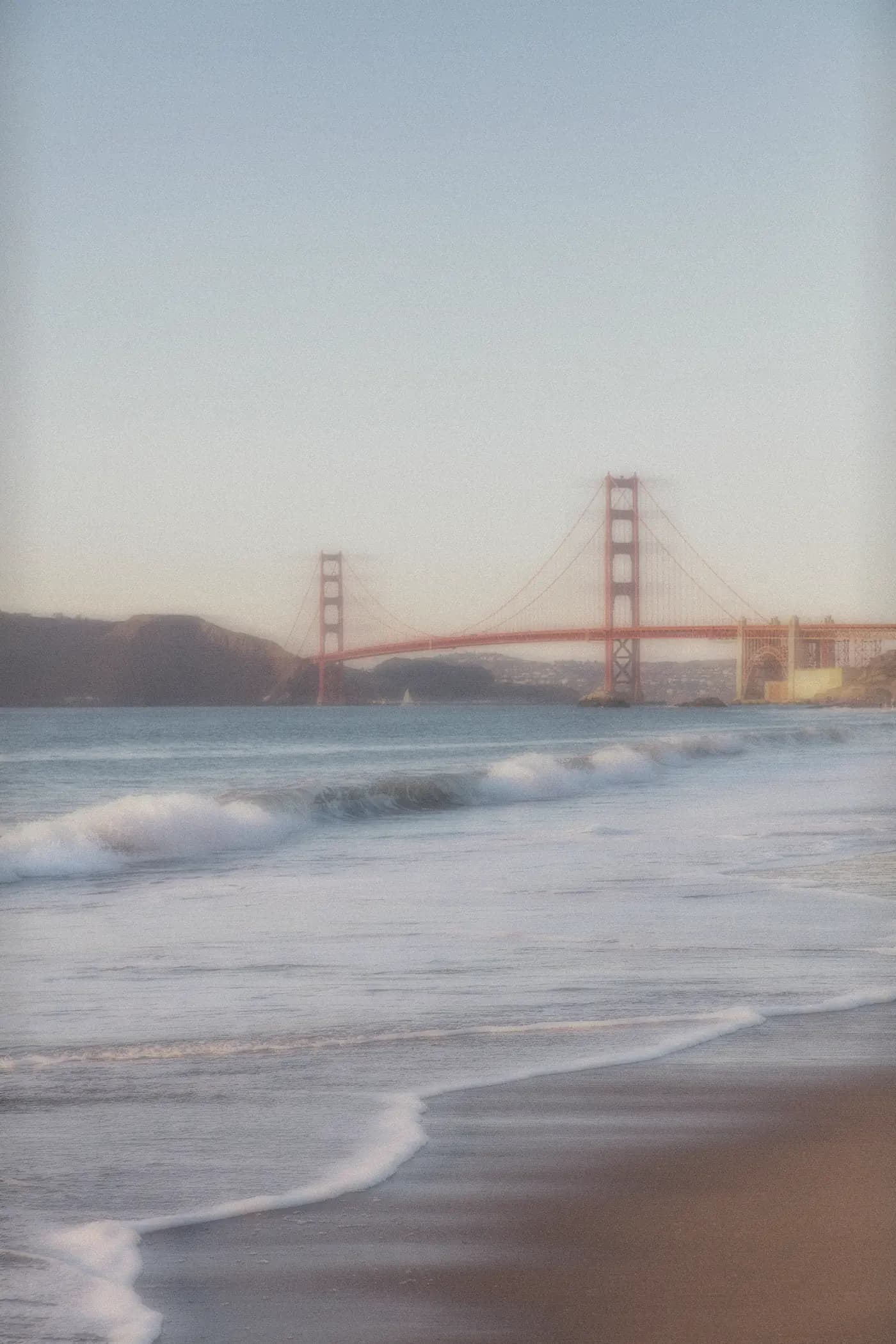 The Golden Gate Bridge seen through fog from Baker Beach